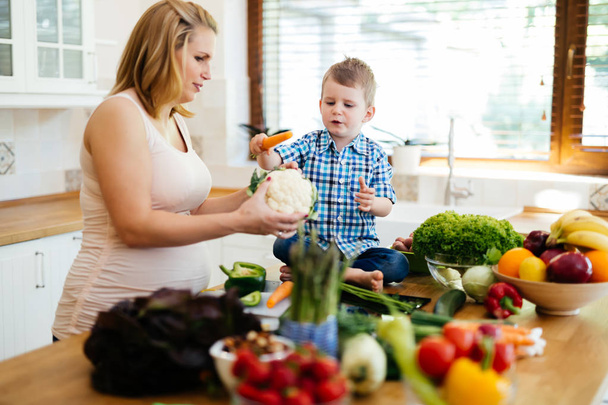 Mother and child preparing lunch from fresh veggies - Foto, Bild