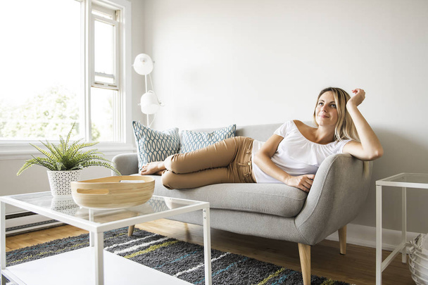 Nice blond ženy sedí na gauči doma - Fotografie, Obrázek