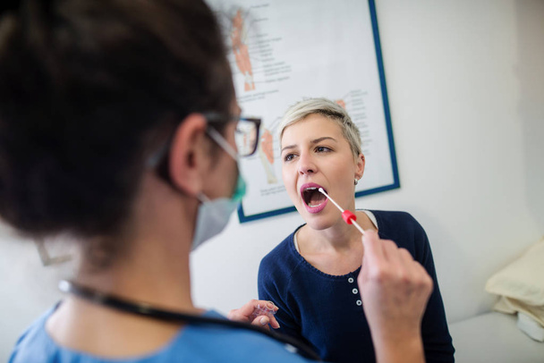 jovem médico examinando mulher loira na clínica moderna
  - Foto, Imagem