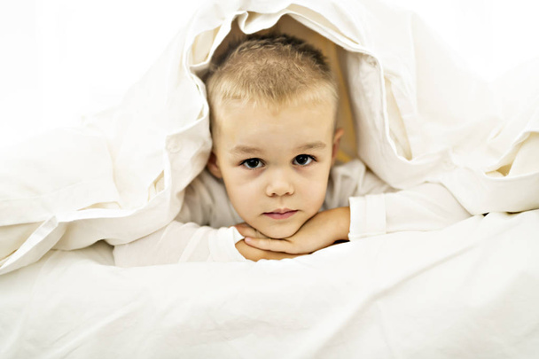 cute four years boy in white bedding - Foto, Imagem