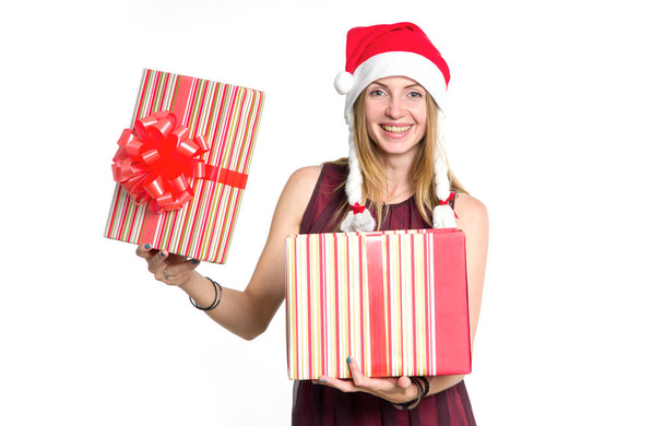 Cheerful woman with a gift box in the hat of Santa Claus. New Year shopping. Christmas gift is a surprise. - Фото, зображення