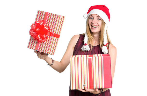 Cheerful woman with a gift box in the hat of Santa Claus. New Year shopping. Christmas gift is a surprise. - Photo, Image