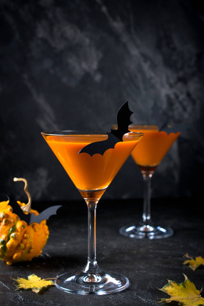 Halloween boisson orange avec des chauves-souris sur fond sombre, effrayant
 - Photo, image