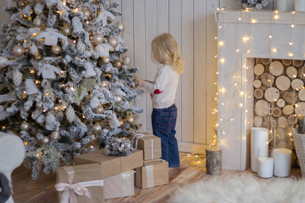 クリスマス ツリー、正月近くに立っている少女。プレゼント - 写真・画像