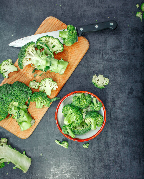 Fresh raw broccoli in a wooden bowl on a dark background.Top view. Free space. - Zdjęcie, obraz