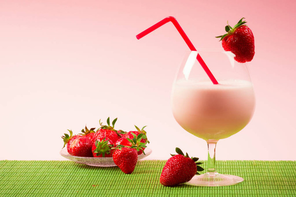 Bebida batida de fresa con fresas sobre fondo rosa
. - Foto, imagen