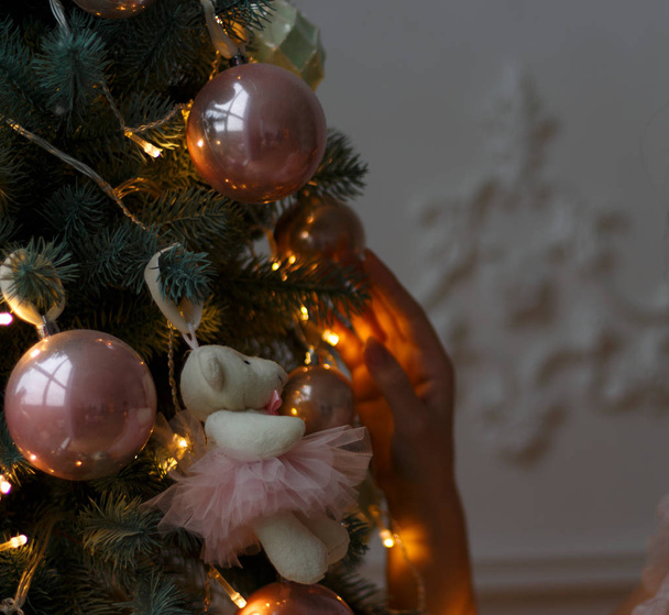 brinquedos e um urso rosa estão pendurados na árvore. decorar a árvore, prepare-se para as férias.Manhã de Natal
 - Foto, Imagem