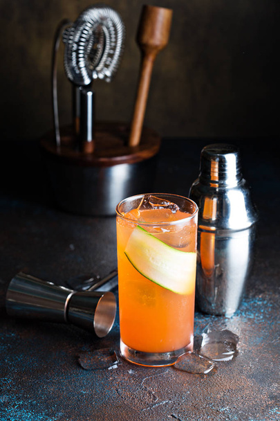 Orange gin cocktail with a cucumber slice - Fotó, kép