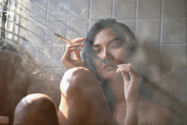 Smoking concept. Sexy women are smoking in the room. Sexy women are relaxing by smoking. Beautiful women have seductive charm. - 写真・画像