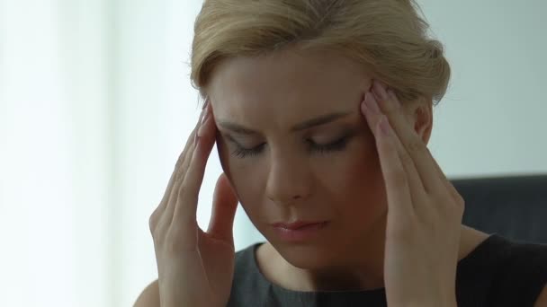 Businesswoman rubbing temples, worrying for deadline, suffering from migraines - Video, Çekim