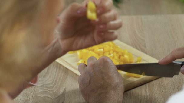 Man hakken peper, vrouw speels stelen slice, gezonde voeding, geen GGO-closeup - Video