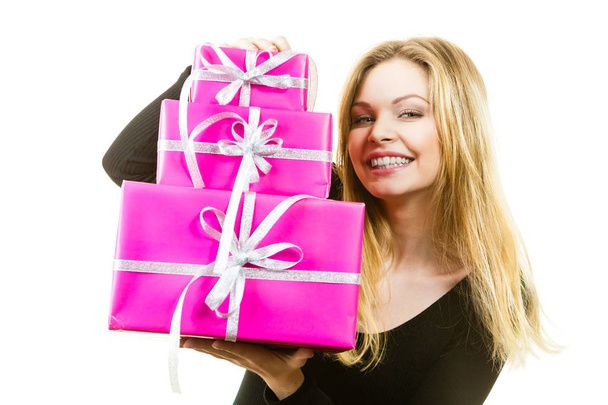 Happy positivie young teenage woman holding big pile of pink gift boxes. Female receiving many presents. - Zdjęcie, obraz