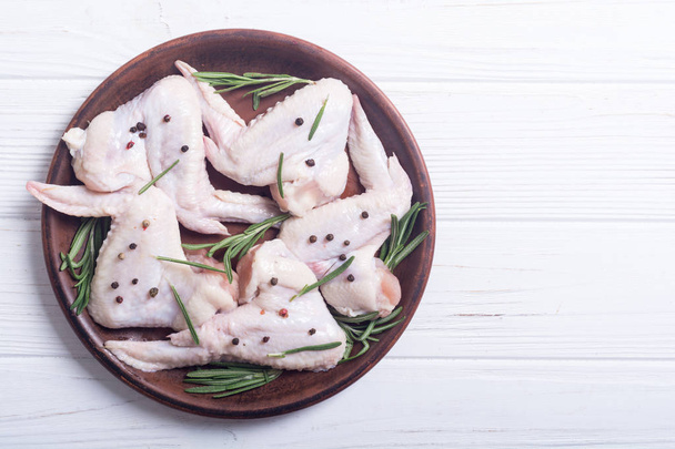 Chicken raw wings with rosemary , garlic , pepper and salt . Ingredient for preparation - Foto, afbeelding