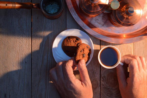 hands take coffee and biscuits from a wooden rustic - Photo, Image
