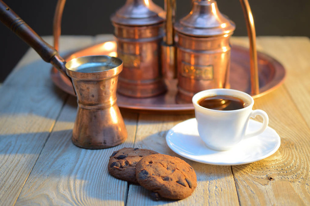 egy keksz és egy csésze kávé mellett a cukrot tálba és egy edénybe, kávé, rusztikus, fából készült tábla - Fotó, kép