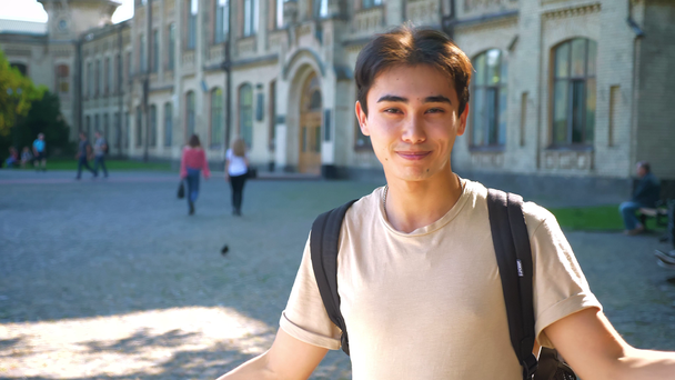Awesome verrast Aziatisch vent vertoont verward gebaar met emotionele gezicht terwijl die naast de oude gebouw alleen - Video