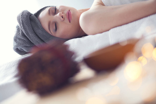 Young woman lying on a massage table,relaxing with eyes closed. Woman. Spa salon - Valokuva, kuva