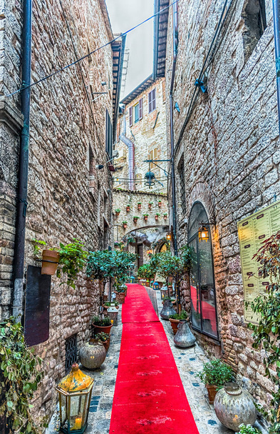 Orta İtalya 'nın en güzel ortaçağ şehirlerinden biri olan Assisi' nin pitoresk ve antik sokaklarında yürüyor. - Fotoğraf, Görsel