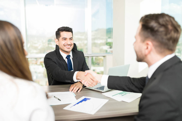 Финансовый консультант заключает сделку с клиентами в офисе
 - Фото, изображение