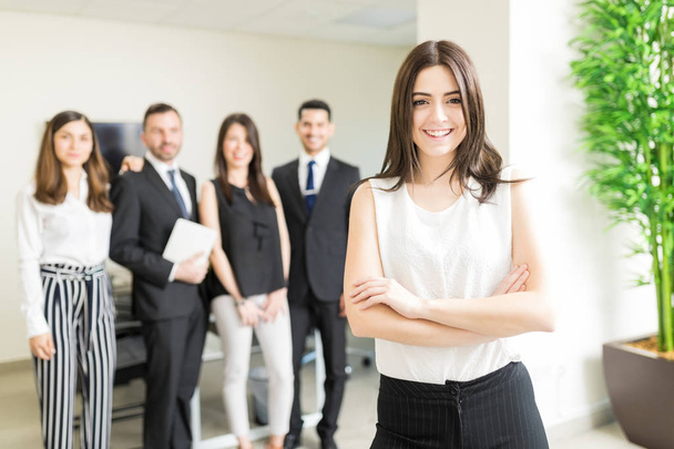 Positiivinen naispuolinen yrityspohatta hymyilee johtavassa organisaatiossa
 - Valokuva, kuva