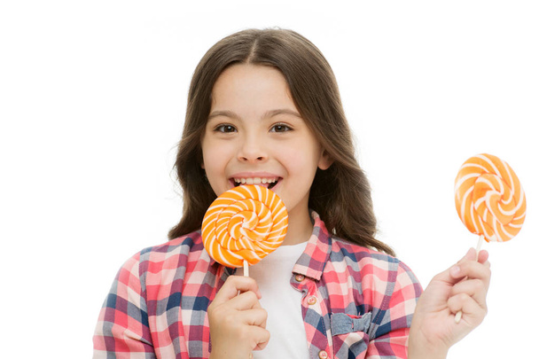 Impressing fact sugar nutrition. Girl child smiling holds lollipop candy. Girl kid with lollipop looks happy. Healthy nutrition and dieting concept. Sweet tooth concept. Baby happy face eat lollipop - Photo, Image
