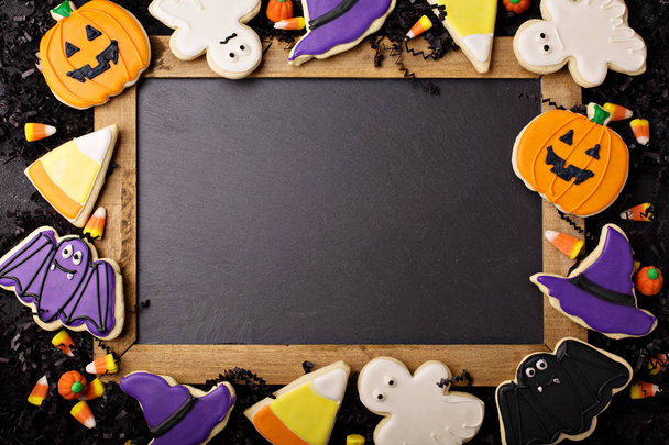 Halloween cookies in the shape of pumpkin, bat, ghost and candy corn with a chalkboard - Valokuva, kuva