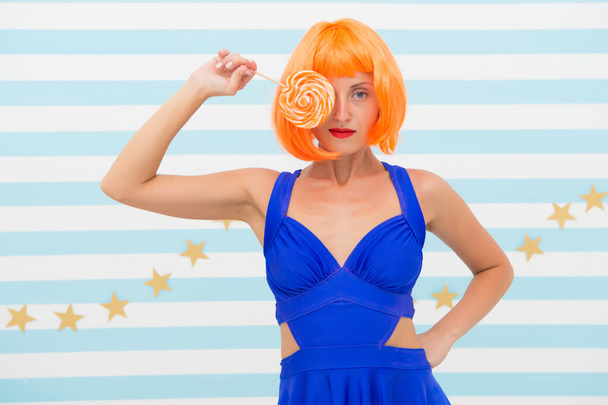 Fashion girl with orange hair having fun. Crazy girl in playful mood. happy pinup model with lollipop in hand. Cool girl with lollipop. Sexy woman. party time. Sweet look. So much fun - 写真・画像