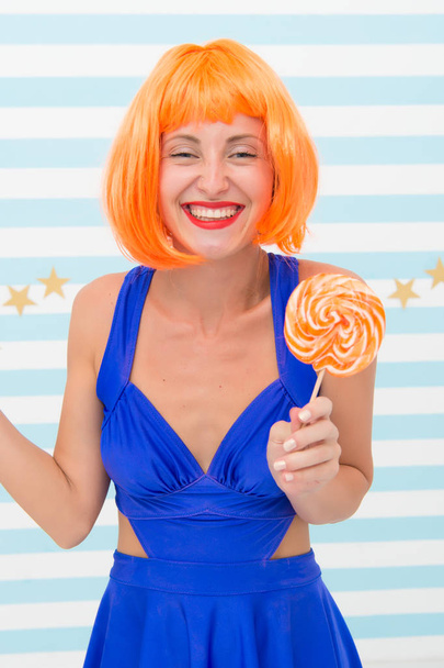 Cool girl with lollipop. Sexy woman. Crazy girl in playful mood. happy pinup model with lollipop in hand. Fashion girl with orange hair having fun. Enjoy party. Going crazy. Sweet look. So much fun - Foto, afbeelding