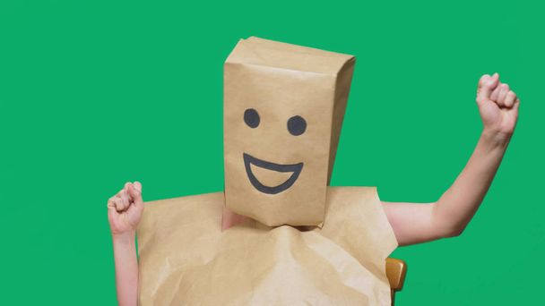 koncepcja emocje, gesty. człowiek z torby papierowe na głowie, malowane emotikon, uśmiech, radość - Zdjęcie, obraz
