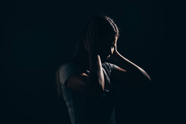 Sad woman in dark room. Depression and anxiety disorder concept - 写真・画像