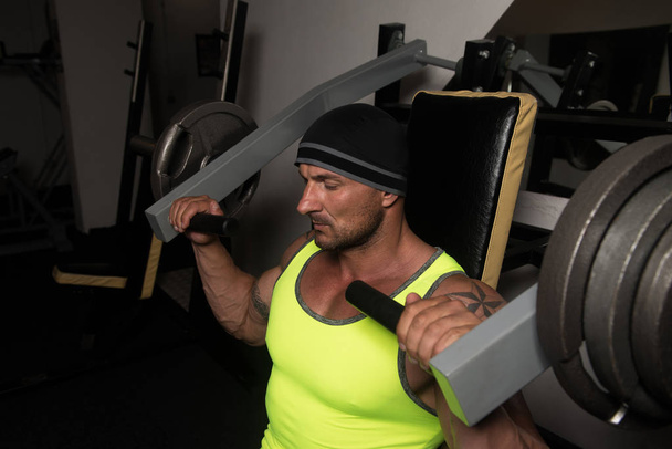 Handsome Athlete Doing Heavy Weight Exercise For Shoulders On Machine - Fotoğraf, Görsel