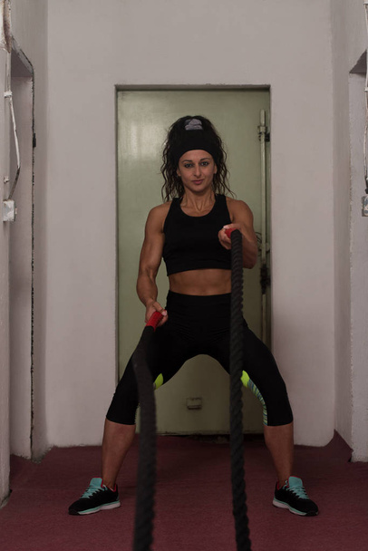 Б'ючись мотузки молоду жінку в тренажерний зал тренування вправи - Фото, зображення