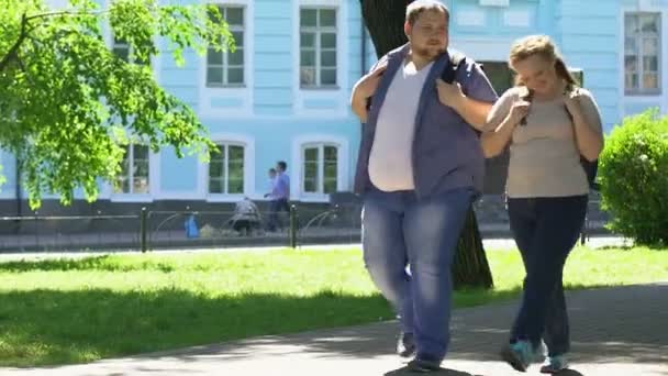 Happy overweight woman and man walking in park, romantic date, body positive - Video