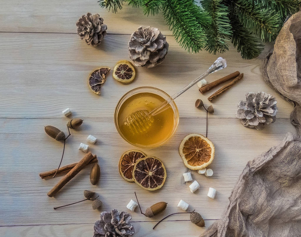 autumn still life with honey, marshmallows, pine and cones, lemon, leaves, on white wooden background top view. object group tea with honey - Фото, зображення