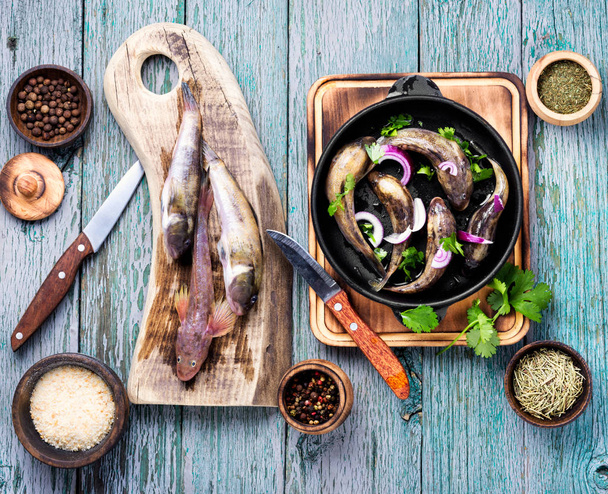 Fresh sea fish in a frying pan on the kitchen table - Photo, Image