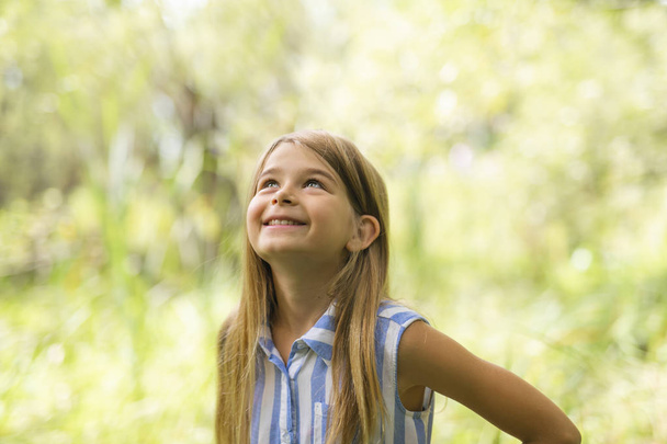 Portrait of a happy young girl outdoors forest - Fotó, kép