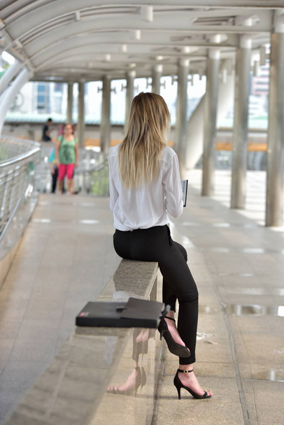 Şehirdeki bankta oturan kadın. - Fotoğraf, Görsel