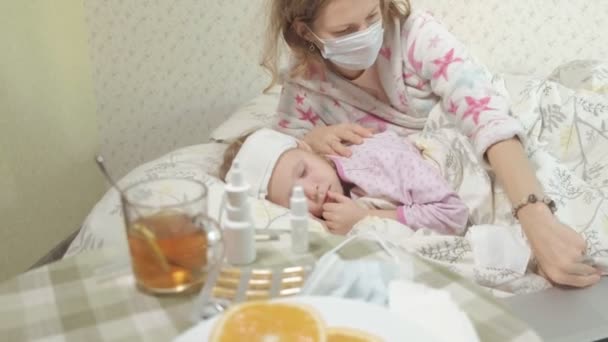 Sick girl with fever Child with fever lying in bed with mother - Felvétel, videó
