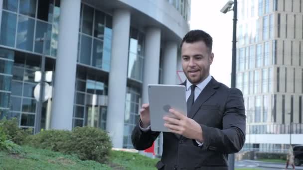 Online Video Chat on Tablet by Walking Businessman - Filmagem, Vídeo
