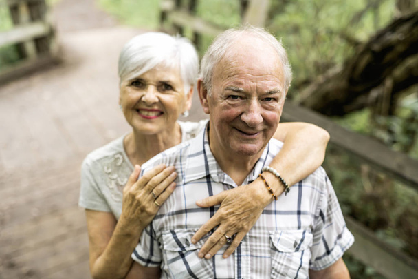 Happy old elderly caucasian couple in a park - Fotó, kép