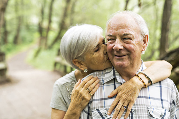 Happy old elderly caucasian couple in a park - 写真・画像