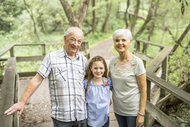 Twee grootouders met grandkid op zomer bos - Foto, afbeelding