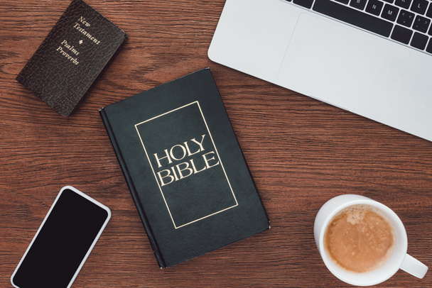 vista superior de la biblia santa con nuevo testamento, gadgets y café en la mesa de madera
 - Foto, Imagen