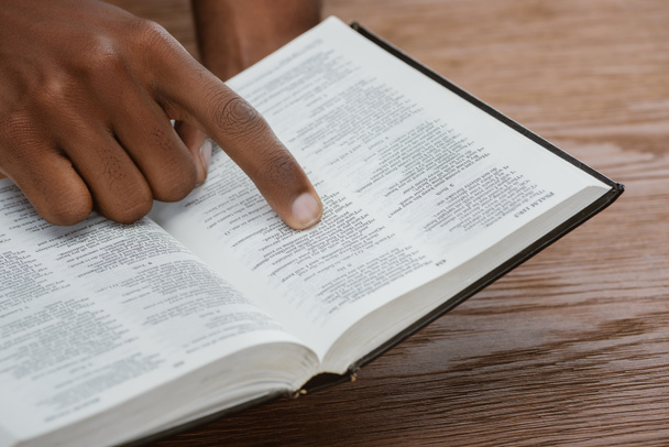 plan recadré de l'homme afro-américain lisant la bible sainte et pointant vers le psaume
 - Photo, image