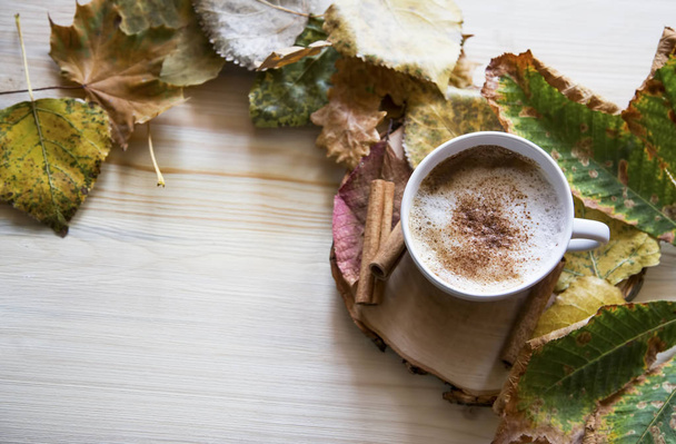 Осенняя чашка кофе, капучино с сушеными листьями, вид сверху
 - Фото, изображение