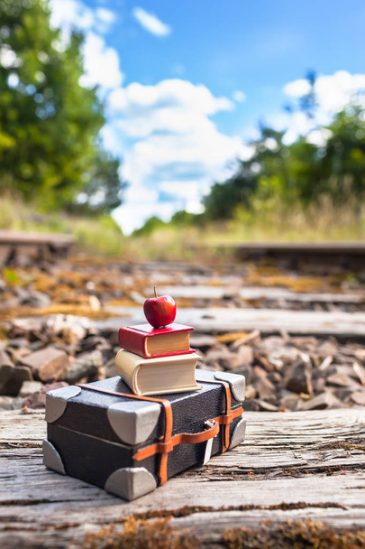 Starych torów kolejowych przez piękną przyrodą, miniaturowe walizkę, książek i apple na sterty o podkładów kolejowych vintage (kopia miejsce) - Zdjęcie, obraz