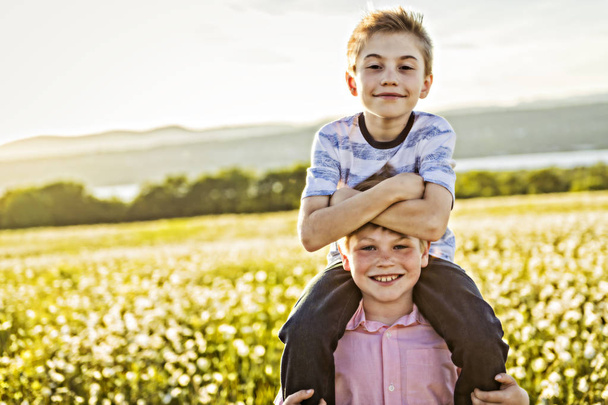 Portrait of two happy cheerful brothers at sunset, outdoor - Foto, afbeelding