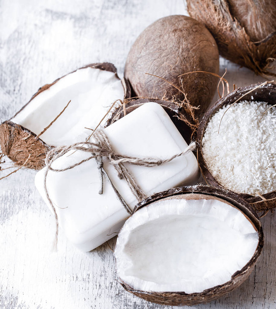 Spa still life of organic cosmetics with coconuts on a light wooden background, body care concept - Foto, Imagen
