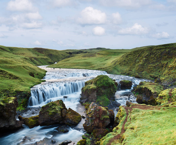 Beautiful cascades on the river Skoga, Iceland. Gorge above the waterfall Skogafoss. Amazing in nature. Green grass and moss - Zdjęcie, obraz