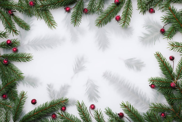 Christmas background with frame of fir branches and holly berries. Flat lay, top view, copy space for text - Photo, Image